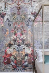 - une chambre avec un papier peint floral sur le mur dans l'établissement Vossia Luxury Rooms & Sicilian Living, à Palerme