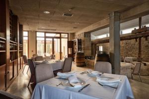 uma sala de jantar com mesas e cadeiras brancas em Hotel La Vida Spa em Aldeayuso