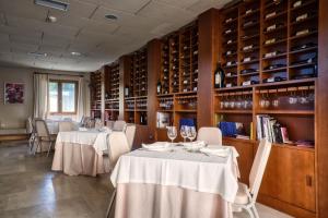 a dining room with two tables and wine bottles at Hotel La Vida Spa in Aldeayuso
