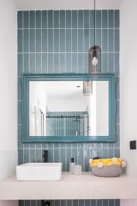 baño con espejo y lavabo en Vossia Luxury Rooms & Sicilian Living, en Palermo