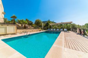 uma piscina com água azul e um deque de madeira em Ideal Property Mallorca - Caselles Petit em Campanet