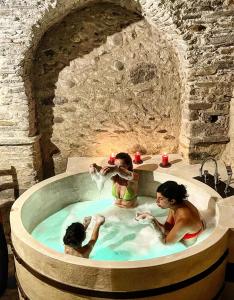un gruppo di bambini che giocano nella vasca da bagno in un muro di pietra di Per Sognare Per Sugnè a Lesegno
