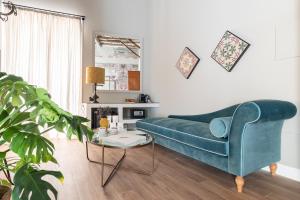 a living room with a blue couch and a table at Vossia Luxury Rooms & Sicilian Living in Palermo