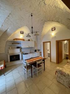 eine Küche mit einem Tisch und ein Esszimmer mit in der Unterkunft VALLE D'ITRIA Trullo Sovrano sul Monte in Cisternino