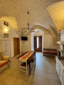 eine Küche mit einem Tisch und einem Sofa in einem Zimmer in der Unterkunft VALLE D'ITRIA Trullo Sovrano sul Monte in Cisternino