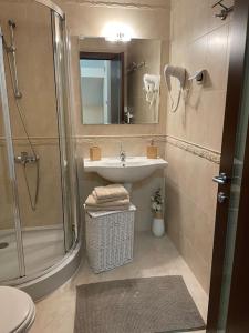 a bathroom with a sink and a shower at Вила 11 - семейна почивка в сърцето на Балкана in Ribarica