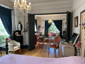 a bedroom with a bed and a living room with chairs at Pretty Victorian Garden Flat in Radipole