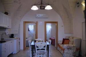 eine Küche und ein Wohnzimmer mit einem Tisch und Stühlen in der Unterkunft VALLE D'ITRIA Trullo Sovrano sul Monte in Cisternino