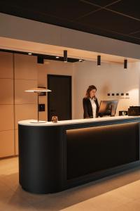 a woman standing at a counter in an office at Roannay - Francorchamps in Francorchamps