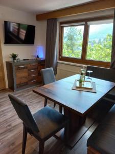 a dining room with a wooden table and a television at Haus Waldfrieden in Sautens