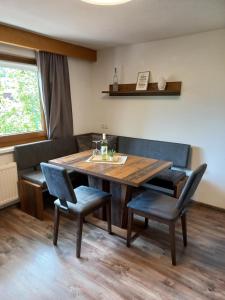 comedor con mesa de madera y sillas en Haus Waldfrieden, en Sautens