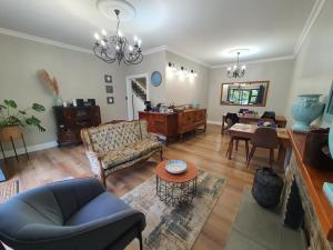 a living room with a couch and a table at Coral Tree Boutique Guesthouse in East London