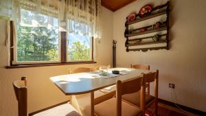 d'une salle à manger avec une table, des chaises et une fenêtre. dans l'établissement Holiday house with a parking space Lokve, Gorski kotar - 18226, à Delnice