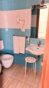 a bathroom with a sink and a toilet and a tub at Hotel Klein Wien in Piano di Sorrento