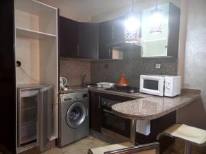 cocina con lavadora y microondas en la barra en Central Aparts Av Prince Moulay Abdellah, en Marrakech