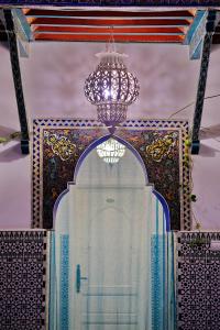una lámpara de araña y un edificio con una puerta. en Riad Hôtel Essaouira, en Marrakech