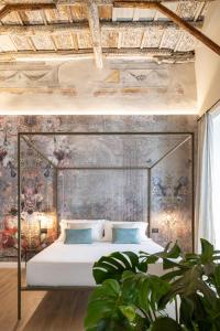 a bedroom with a large bed with a painting on the wall at Vossia Luxury Rooms & Sicilian Living in Palermo