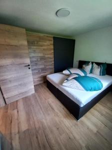 1 dormitorio con 1 cama grande y pared de madera en Haus Waldfrieden, en Sautens