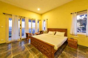 1 dormitorio con 1 cama grande y ventanas en Mysterious mountain, en Ooty