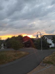 un lampione davanti a una casa con il tramonto di Ferienwohnung Im Distelweg a Scheid