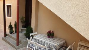 a table with chairs and a table with flowers on it at Casa Arion in Băile Herculane