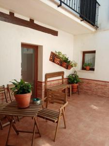 eine Terrasse mit Tischen, Stühlen und Topfpflanzen in der Unterkunft Apartamento Turístico El Empedrado de M&G in Colmenar de Oreja