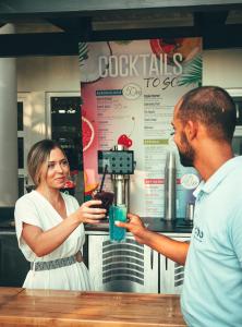 un hombre y una mujer parados en un mostrador con una bebida en ECHO Boutique Rooms, en Rabac