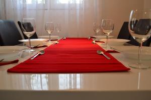 a table with a red place mat on a table with wine glasses at Apartments with a swimming pool Gizdavac, Zagora - 12053 in Neorić