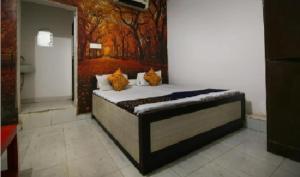 a bed in a room with a painting on the wall at Hotel Classic Gold By WB Inn in Agra