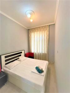 um quarto com uma cama branca e uma janela em M Estate. 2 Room Home in Targovu em Baku