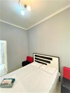 um quarto com uma cama branca e cadeiras vermelhas em M Estate. 2 Room Home in Targovu em Baku