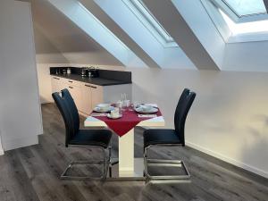 a dining room with a table and black chairs at Sorinas Home - Comfortable Apartment near Graz - Free Parking in Wagersbach