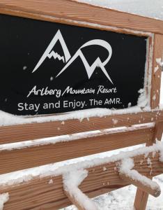 Una señal para una montaña de flechas y disfrutar de la amr en Arlberg Mountain Resort, en Pettneu am Arlberg