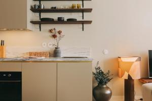 a kitchen with white cabinets and a counter top at Village Aparthotel By BOA in Porto