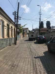 una calle adoquinada con un camión blanco aparcado en ella en ЦЕНТР ГОРОДА СПОКОЙНАЯ УЛИЦА en Kutaisi
