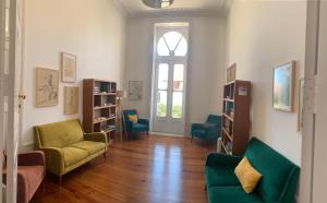 ein Wohnzimmer mit 2 Stühlen und einem Sofa in der Unterkunft HI Vila do Conde - Pousada de Juventude in Vila do Conde