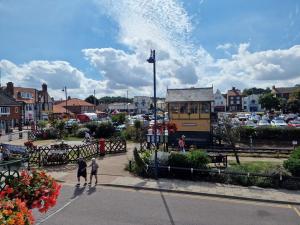 a group of people walking on a city street at The Crows Nest - Sheringham in Sheringham