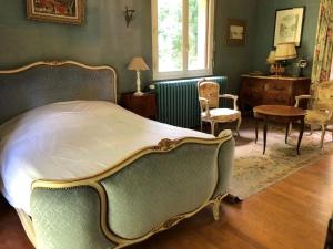 Schlafzimmer mit einem Bett, einem Tisch und Stühlen in der Unterkunft Villa au cœur des vignes de Chavignol in Sancerre
