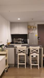a kitchen with a counter and two stools in it at Live Your Dream Khaoyai in Phayayen