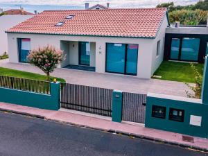 a house with a fence in front of it at Populo's Place in Ponta Delgada