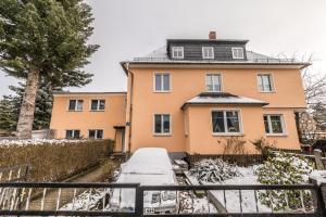 una casa con la neve davanti di Ferienwohnungen SIRI a Burgstaedt