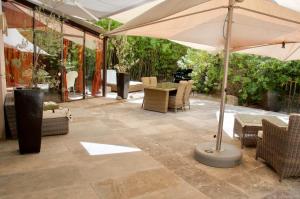 un patio con sombrilla, mesa y sillas en LASUITE Domaine Bertuli, heated Pool, Aircon en Oppède
