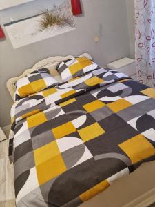 łóżko z czarno-żółtym kocem w obiekcie Belle chambre avec balcon w mieście Arques