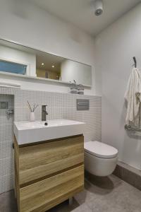 La salle de bains est pourvue d'un lavabo et de toilettes. dans l'établissement V Ajax Warsaw Bed&Breakfast ROOMS, à Varsovie
