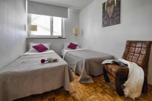ein Hotelzimmer mit 2 Betten und einem Stuhl in der Unterkunft V Ajax Warsaw Bed&Breakfast ROOMS in Warschau