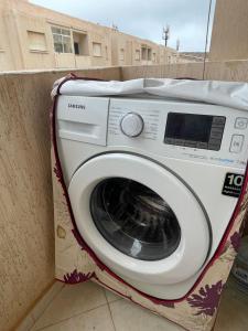 uma máquina de lavar roupa sentada numa caixa ao lado de uma parede em PROMO Appartement Familial avec WiFi em Al Hoceïma