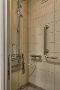 La salle de bains est pourvue d'une douche et d'une porte en verre. dans l'établissement V Ajax Warsaw Bed&Breakfast ROOMS, à Varsovie