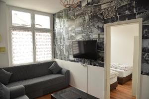 a living room with a couch and a tv on a wall at Design Apartments 1 in Dortmund