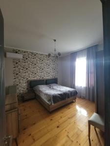 um quarto com uma cama e uma parede de pedra em guest house TSVARA em Vani