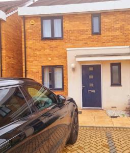 un coche aparcado frente a una casa de ladrillo en Modern home with Netflix, NowTV & 2private parking en East Tilbury